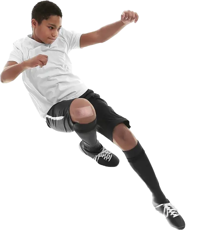 A boy playing soccer, with Cordran Tape on his knee